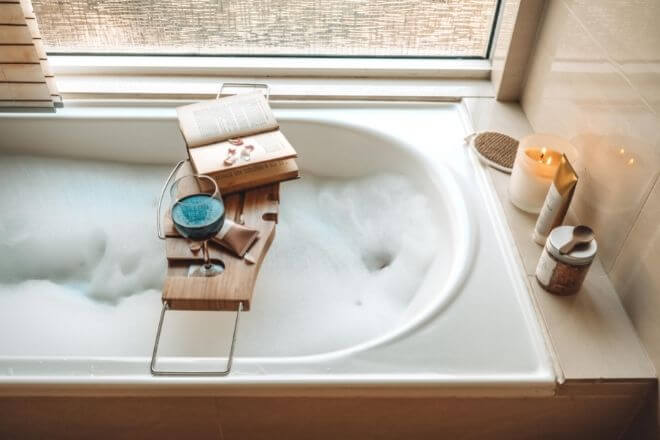 book and tray laying over bathtub